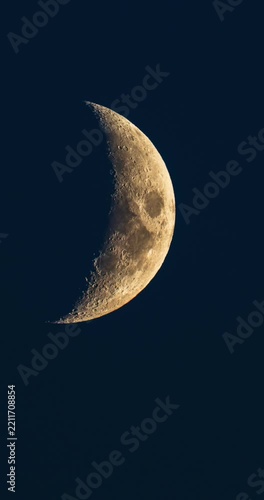 Vertical 9:16 time lapse of beautiful detailed golden crescent moon moving in dark blue night sky