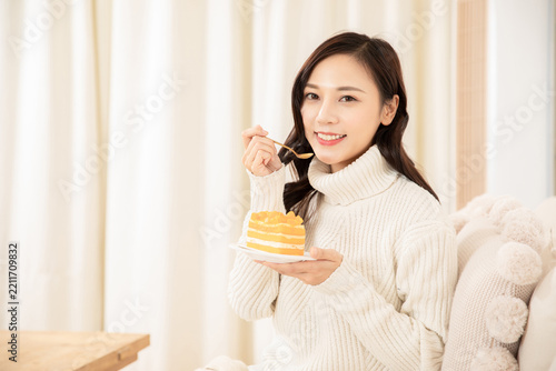 Happy Woman Eating Layered Cake at Home
