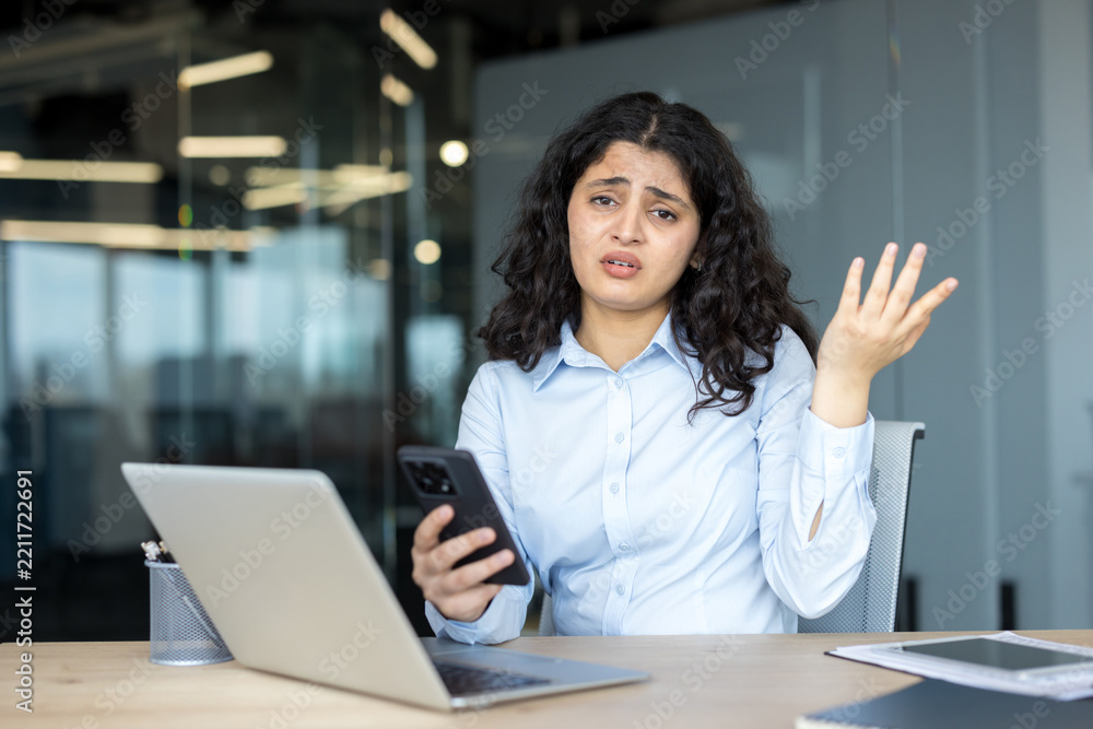 Fototapeta premium Confused young woman experiencing problem with smartphone