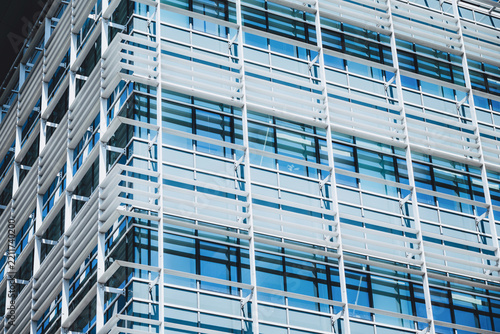 Modern architecture building facade featuring glass panels, steel frames, and horizontal sunshade louvers