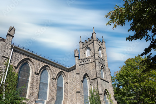 Exterior of a large stone church in a small town, stone, windows, blue skies, nobody