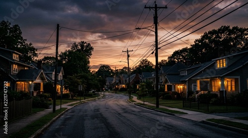 Suburban Street at Dusk with Warmly Lit Houses and Overhead Wires