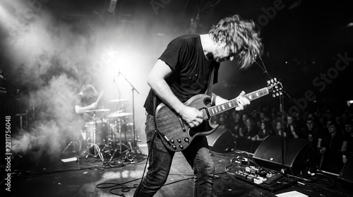 Energetic Rock Guitarist Performing Live on Stage with Band in Smoky Black and White Concert Atmosphere