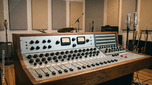 Vintage analog audio mixing console in a retro recording studio.
