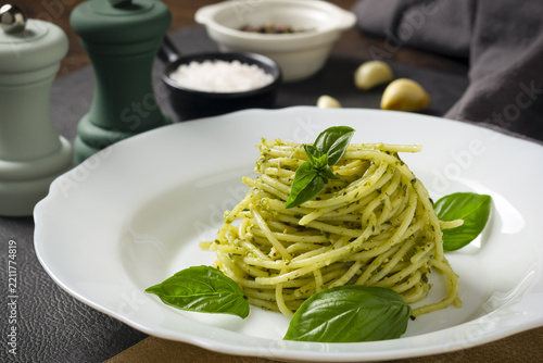 Obraz na plátně Pasta spaghetti with pesto, basil, garlic and spices on dark table