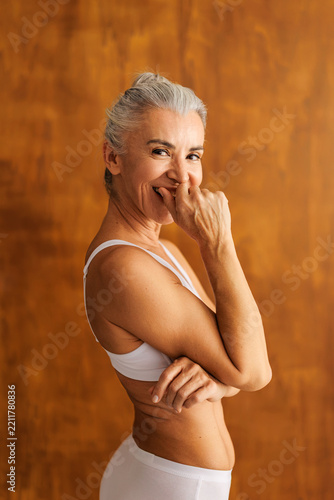 Senior woman smiling shyly showing body positivity