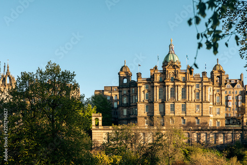 Daylight horizontal photograph of the iconic Bank of Scotland head office building in Edinburgh, Scotland, showcasing its grand architecture and green dome above green trees