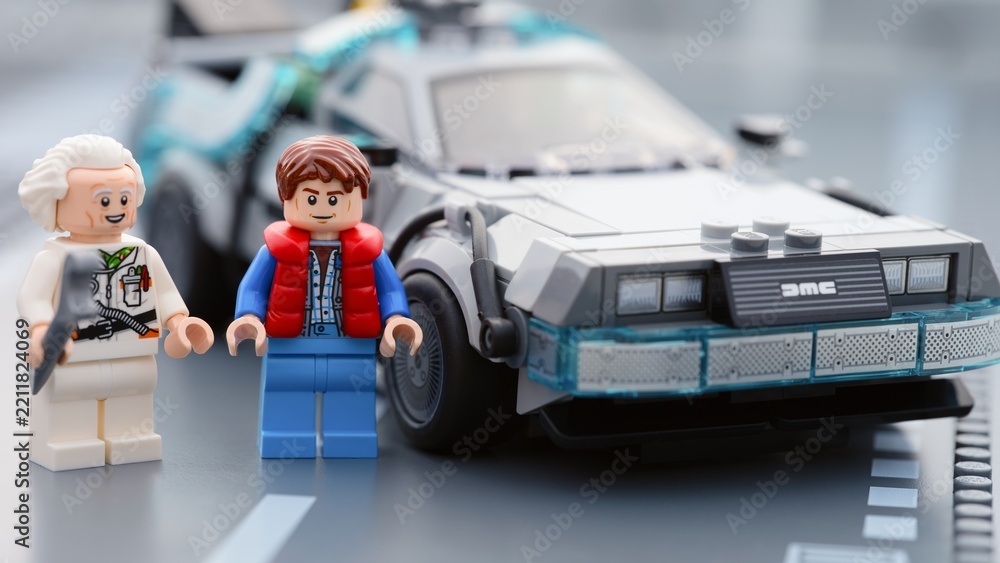 Obraz premium Tambov, Russian Federation - June 20, 2026 Lego minifigures of Marty McFly and Doc Brown standing near the DeLorean time machine car from Back to the Future on a road baseplate.