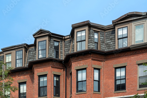 Brick building facade with bay windows in Boston's South End under blue sky