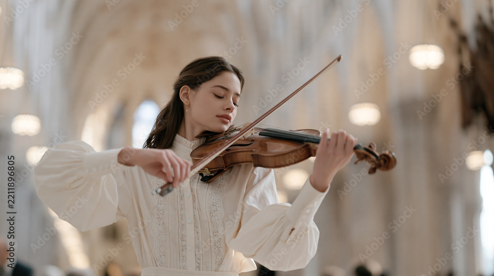 Obraz premium A violinist pauses mid-performance inside a grand cathedral nave and looks upward at the vaulted ceiling, natural reverence, music and spirituality, sacred space inspiration,