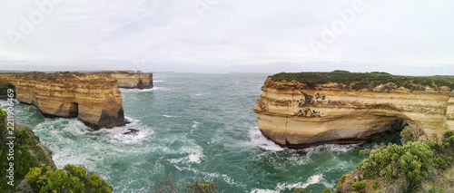 Obraz na plátně Panoramic view of eroded limestone cliffs and rock arches above turquoise sea al