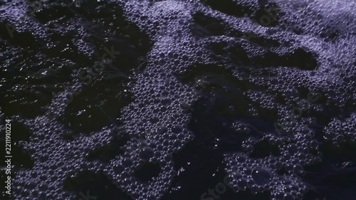 Close up of churning dark water and foam bubbles