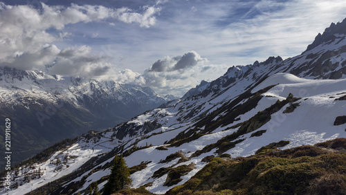 Snowy alpine slopes above Chamonix with dramatic mountain valley and rugged peaks of the Mont Blanc Massif, French Alps, France