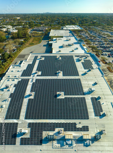 Aerial view of many photovoltaic panels installed on shopping mall roof top for producing of green ecological electricity. Production of sustainable energy concept