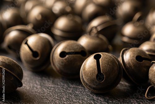 Christmas jingle bells, many Christmas jingle bells on a dark surface, selective focus.