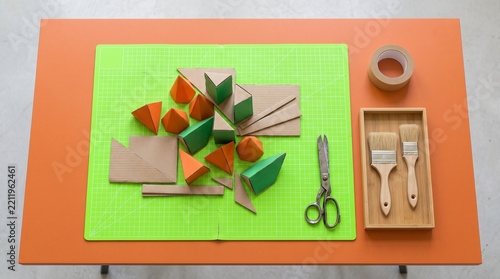 Overhead cardboard geometry study on a vivid worktable