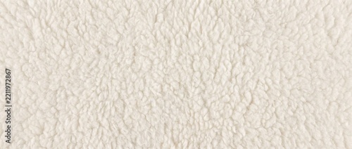 Soft white polar fleece texture background. Fluffy sherpa faux fur textile macro. Warm woolly sheepskin fabric backdrop with copy space