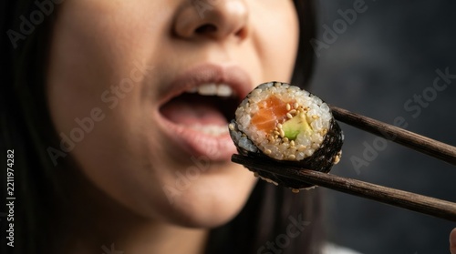 Woman Eating Sushi with Chopsticks