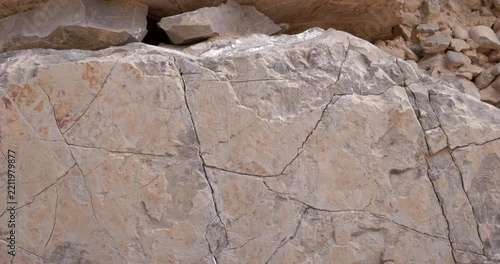 Slow Motion Slider Across Fractured Rock Face With Cracks and Weathered Stone Texture