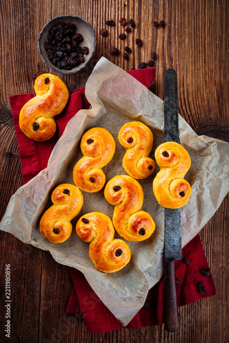 Classic artisan homemade  traditional Swedish  St Lucia buns lussekatter served as top view on baking paper