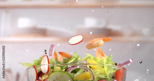 Shrimp falling onto fresh vegetable salad in slow motion