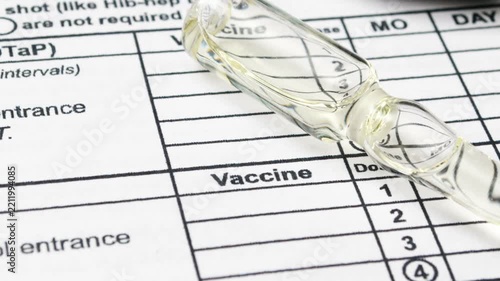 Close up of syringe on vaccine record
