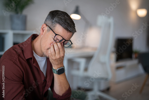 Man suffering from headache and eye strain at home office