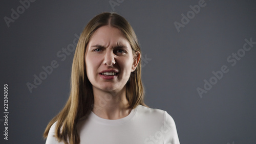 Obraz na plátně Young woman frowning with a negative facial expression, indicating displeasure o