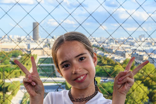 Girl smiles brightly, waving peace signs