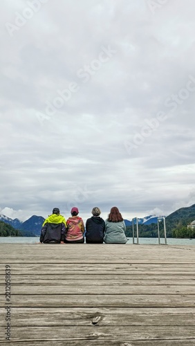 Four Friends Enjoying a Peaceful Lakeside Mountain View Together.