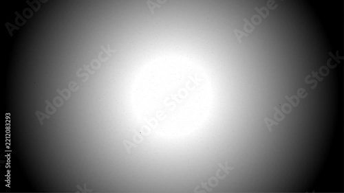Authentic Vintage Film Grain Overlay Texture with Dust Motes, Scratches, and Heavy Vignette Effect on a Bright Glowing Center for Retro Cinematic Video Editing and Analog Aesthetics