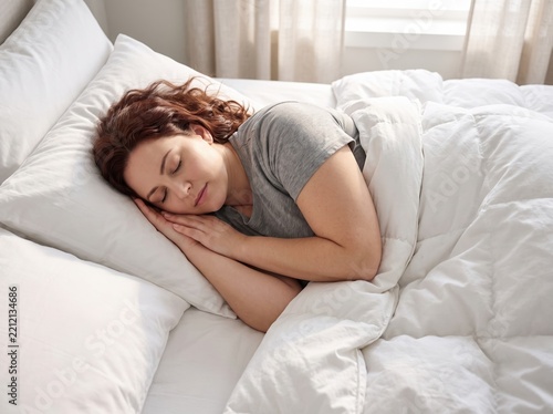 Peaceful Plus Size Woman Sleeping Soundly in a Bright Bedroom