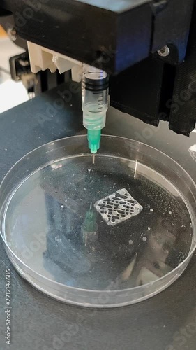 Bio 3D printer. A small bio 3D printer printed small sample from hydrogel on work surface. High-tech robotic device for layer-by-layer creation. New modern additive manufacturing. 3D printing Vertical