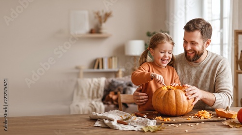 Family Carving Pumpkins Together at Home Wooden Table Natural Lighting with Copy Space