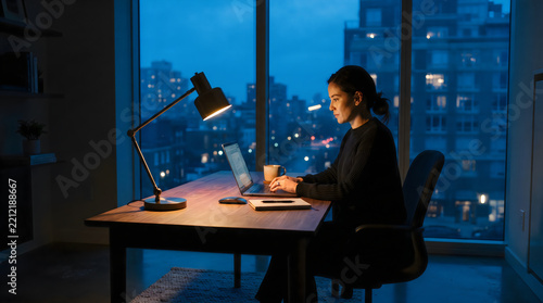 Person working at modern desk with city night view