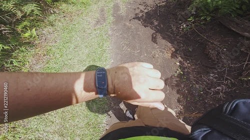 Checking Smartwatch Fitness Tracker While Hiking On Outdoor Trail During Sunny Day