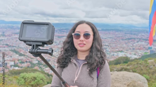 Tourist Taking Selfie With Camera on Stick Overlooking Bogotá With Colombian Flag and City View
