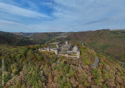 vue aérienne panoramique du château médiéval de Bourscheid au Grand Duché du Luxembourg. Le donjon, les tours et ses fortifications restaurées sont au sommet d'une colline boisée. Septembre 2026