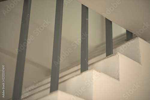 Concrete staircase steps with vertical metal railing in a modern indoor space
