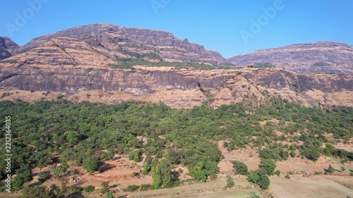Drone view of majestic rugged cliffs and steep valleys covered in lush green vegetation