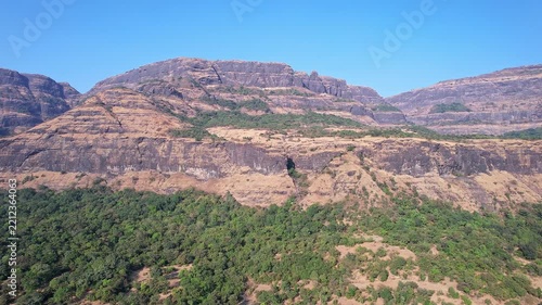 Drone view of majestic rugged cliffs and steep valleys covered in lush green vegetation