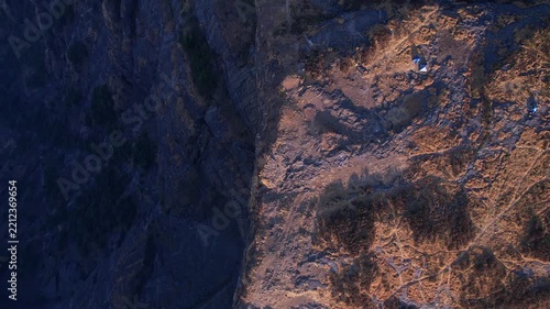 Aerial landscape featuring towering stone walls across vast rugged terrain beneath blue skies