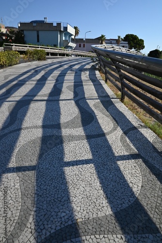 Paved Promenade with Geometric Railing Shadows.