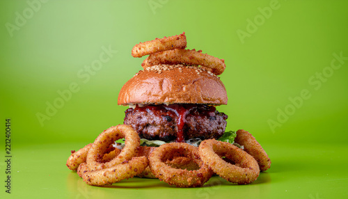 Premium cheeseburger with crispy onion rings arranged for eye-catching restaurant advertising and food marketing.