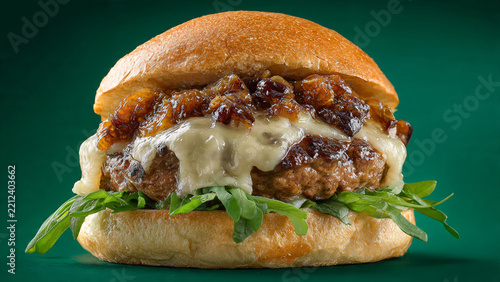 Premium gourmet cheeseburger with melted cheese and caramelized onions for restaurant advertising, menu covers and commercial food branding.