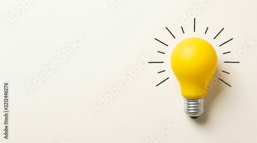 Yellow light bulb on beige background radiating creativity and innovation symbolically.