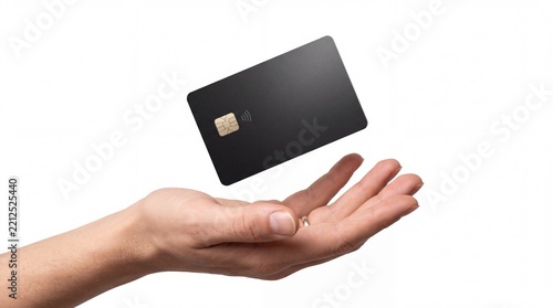 Blank black credit card levitating above human open hand on white background