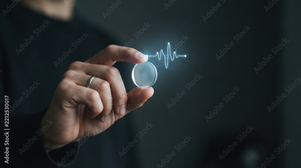 Obraz premium Healthcare innovation supports medical spending through glowing digital heart signal held by hand in dark clinical setting