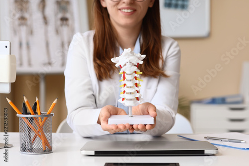 Chiropractic care and spinal health, doctor holding cervical spine model for ...