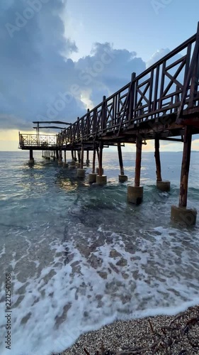 Peaceful Mediterranean Morning with a Weathered Wooden Pier and Blue Sea